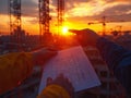 The hands of engineers and architects pointing at a document design on the construction site sun set Royalty Free Stock Photo