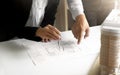 Hands of Engineers working on blueprint at a workplace, Construction and building concept