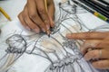 hands erasing lines on a pencildrawn dress to refine the design Royalty Free Stock Photo