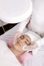 hands of Esthetician performing facial cleansing, applying tonic with cotton pads, skin care concept, closed detail shot