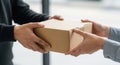 Hands exchanging a parcel box in a bright office environment Royalty Free Stock Photo