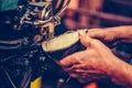 Hands of an experienced shoemaker stitching a part of the shoe in a shoe factory