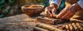 Hands expertly assemble cigars on a rustic table. Focused craftsmanship is evident as the individual rolls the tobacco Royalty Free Stock Photo