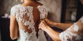 Hands fastening the wedding dress at the bride back , concept of Graceful elegance