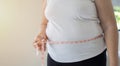 Hands of fat overweight woman measuring her waist size with a measuring tape Royalty Free Stock Photo