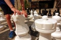 The hands and feet of a boy moving the knight piece on a giant outdoor chess board Royalty Free Stock Photo