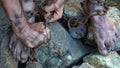 Hands and feet of a slave entangled in iron chains. An attempt to break free from slavery. The symbol of slave labor. Hands in