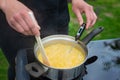 Hands of a female chef prepare citrus syrup. Culinary thermometer