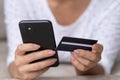 Hands of female customer holding smartphone and credit card