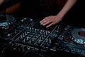 Hands of female DJ adjusting sound during disco party
