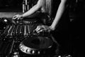 Hands of female DJ adjusting sound during disco party