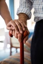 Hands of female doctor and senior man holding walking cane in retirement home Royalty Free Stock Photo