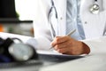 Hands of female GP making notes with silver pen Royalty Free Stock Photo