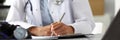 Hands of female GP making notes with silver pen Royalty Free Stock Photo