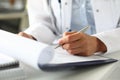 Hands of female GP making notes with silver pen Royalty Free Stock Photo