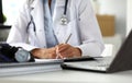 Hands of female GP making notes with silver pen Royalty Free Stock Photo