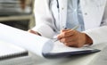 Hands of female GP making notes with silver pen Royalty Free Stock Photo