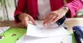 Hands of female secretary hold clerical puncher and punch A4 paper