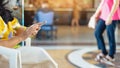 Hands of female traveler wear face mask sit to use smartphone while wait for hotel check in at hotel lobby. Business Woman waiting Royalty Free Stock Photo