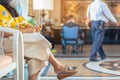 Hands of female traveler wear face mask sit to use smartphone while wait for hotel check in at hotel lobby. Business Woman waiting Royalty Free Stock Photo