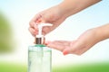 Hands female using wash hand sanitizer gel pump dispenser blurry green nature background Royalty Free Stock Photo