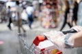 Hands of female wearing plastic gloves pushing a shopping cart to prevent spread infection of COVID-19,Coronavirus,plastic gloves