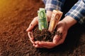 Hands with fertile soil and euro money banknotes