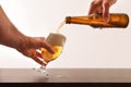 Hands filling a beer glass on wood table isolated white Royalty Free Stock Photo