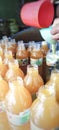 Hands are filling bottles with fresh beverage products, tamarind turmeric, KUNYIT ASAM
