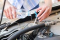 Hands of filling fresh water into the canister of the car windscreen wiper system.