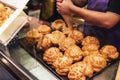 Hands filling vanilla cream with cream sack inside freshly baked Vanilla Choux Cream Puffs for sell. Fresh Baked Bakery