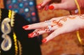 Hands and fingers are drawn to henna . Female hand with henna tattoo . Soft selective focus, close up . There are red lacquer and Royalty Free Stock Photo