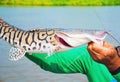 Hands of a fisherman holding a Cachara fish with black stripes Royalty Free Stock Photo