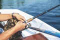 Hands fisherman holding fishing rod and reel handle is rotated Royalty Free Stock Photo