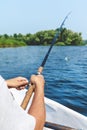 Hands fisherman holding fishing rod and reel handle is rotated Royalty Free Stock Photo