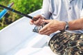 Hands fisherman holding fishing rod and reel handle is rotated Royalty Free Stock Photo