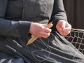 Hands of a fisherman`s wife weaving a new fishing net for fish, traditional clothing,