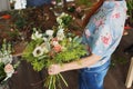 hands of florist collect wedding bouquet at work