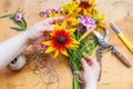 Hands of florist making flowers bouquet