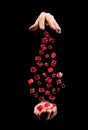 Hands with flying red dice on black background