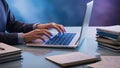Hands of a focused programmer with trimmed fingernails seated at a sleek modern desk