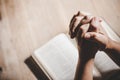 Hands folded in prayer on a Holy Bible in church concept for faith Royalty Free Stock Photo