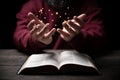 Hands folded in prayer on a Holy Bible in church concept for faith, spirituality and religion, man praying in morning. Man hand