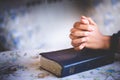 Hands folded in prayer on a Holy Bible in church concept for faith, spirituality and religion, woman praying on holy bible in the Royalty Free Stock Photo