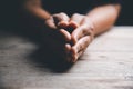 Hands folded in prayer on a Holy Bible in church concept for faith, spirituality and religion, woman praying on holy bible in the Royalty Free Stock Photo