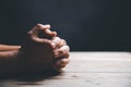 Hands folded in prayer on a Holy Bible in church concept for faith, spirituality and religion, woman praying on holy bible in the Royalty Free Stock Photo