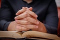 Hands folded in prayer on a Holy Bible in church concept for faith, spirtuality and religion Royalty Free Stock Photo