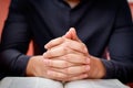 Hands folded in prayer on a Holy Bible in church concept for faith, spirtuality and religion Royalty Free Stock Photo