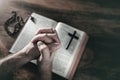 Hands folded in prayer on a Holy Bible in church, faith, spirtuality and religion Royalty Free Stock Photo