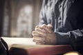 Hands folded in prayer on a Holy Bible in church, faith, spirtuality and religion Royalty Free Stock Photo